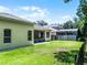 Serene backyard with a screened lanai, green lawn, and wooded backdrop, creating a private oasis at 2026 Winding Oaks Dr, Orlando, FL 32825