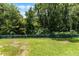 Green backyard with a charming green picket fence surrounded by mature trees at 2026 Winding Oaks Dr, Orlando, FL 32825