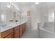 Bright bathroom with double sink vanity, soaking tub, and tiled floors at 2026 Winding Oaks Dr, Orlando, FL 32825