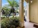 A column frames the view of the exterior, showcasing lush landscaping and a charming neighborhood street at 2026 Winding Oaks Dr, Orlando, FL 32825