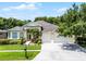 Beautiful single-story home with a lush green lawn, a three-car garage, and verdant landscaping at 2026 Winding Oaks Dr, Orlando, FL 32825