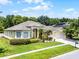 Single-story home featuring a manicured lawn, lush landscaping, and a driveway leading to the three-car garage at 2026 Winding Oaks Dr, Orlando, FL 32825