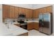 Kitchen with stainless steel appliances, light wooden cabinetry, and white countertops at 2026 Winding Oaks Dr, Orlando, FL 32825