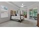 Bright main bedroom with large windows, a four-poster bed, and screened patio access at 2026 Winding Oaks Dr, Orlando, FL 32825