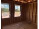 Unfinished bedroom space with two windows, exposed studs, wiring, and flooring to be installed at 2371 Zuni Road, St Cloud, FL 34771