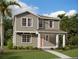 Inviting two-story home with a covered porch, lush landscaping, and a well-manicured lawn at 2371 Zuni Road, St Cloud, FL 34771