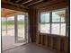 An unfinished living room with framed walls and windows opening to an outdoor patio at 2371 Zuni Road, St Cloud, FL 34771