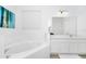 Bright bathroom with a soaking tub, white cabinets, and neutral tile floors at 2209 Crofton Ave, Davenport, FL 33837