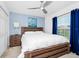 Comfortable bedroom with a wooden bed frame, ceiling fan, and bright natural light at 2209 Crofton Ave, Davenport, FL 33837