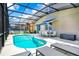 Relaxing screened-in pool area with ample seating, lounge chairs and outdoor dining space at 2209 Crofton Ave, Davenport, FL 33837
