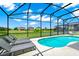 Relaxing screened-in pool area with ample seating, lounge chairs and view of the lake at 2209 Crofton Ave, Davenport, FL 33837
