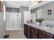 Bathroom featuring a double vanity with granite countertops, tiled floors, and a glass-enclosed walk-in shower at 269 Ludisia Loop, Davenport, FL 33837