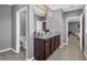 Bathroom featuring double sinks with granite countertop and dark brown cabinets at 269 Ludisia Loop, Davenport, FL 33837