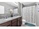 The bathroom features granite countertops, double sinks and a shower/tub combo with a decorative shower curtain at 269 Ludisia Loop, Davenport, FL 33837