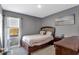 Bedroom featuring a neutral color scheme with a full size bed, side table, and beachy wall art at 269 Ludisia Loop, Davenport, FL 33837
