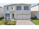 Two-story home featuring a well-manicured lawn and a spacious two-car garage, enhancing curb appeal at 269 Ludisia Loop, Davenport, FL 33837