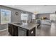 Modern kitchen island featuring a granite countertop, stainless steel appliances, and an open layout to the dining and living area at 269 Ludisia Loop, Davenport, FL 33837