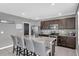 Contemporary kitchen with granite counters, stainless steel appliances, tile backsplash, and an island with barstool seating at 269 Ludisia Loop, Davenport, FL 33837