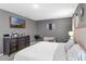 Inviting main bedroom with neutral decor, carpeted floors, a large dresser, and a mounted TV for relaxing evenings at 269 Ludisia Loop, Davenport, FL 33837
