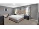 Serene main bedroom featuring neutral tones, carpeted floors, and ample natural light from the two large windows at 269 Ludisia Loop, Davenport, FL 33837