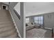 Carpeted staircase leading to the upper level, adjacent to a living room with a comfortable sectional sofa and neutral colors at 269 Ludisia Loop, Davenport, FL 33837
