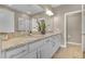 Bathroom featuring double sink vanity with granite countertop, white cabinets and a large mirror at 2936 Econ Landing Blvd, Orlando, FL 32825