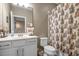Cozy bathroom featuring a vanity with single sink, mirror, and a leaf-patterned shower curtain at 2936 Econ Landing Blvd, Orlando, FL 32825