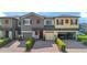 Three-story townhome with attached garages, landscaped frontage, and red and grey exterior at 2936 Econ Landing Blvd, Orlando, FL 32825