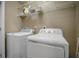 Functional laundry area with washer and dryer, overhead shelving, and neutral decor at 2936 Econ Landing Blvd, Orlando, FL 32825