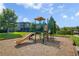 Community playground with slide and climbing structures in a green, grassy setting at 2936 Econ Landing Blvd, Orlando, FL 32825