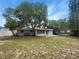 Image of the home's backyard with a lush, green lawn and mature trees at 300 Avenue E Se, Winter Haven, FL 33880