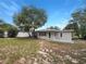 Expansive backyard with a concrete patio, mature trees, and a pristine fence, offering a private outdoor retreat at 300 Avenue E Se, Winter Haven, FL 33880