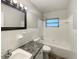 Well-lit bathroom with a classic tile surround, a practical vanity, and a clean, functional layout at 300 Avenue E Se, Winter Haven, FL 33880