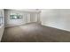 Spacious, carpeted living room featuring neutral walls, windows, and a doorway for easy flow at 300 Avenue E Se, Winter Haven, FL 33880