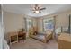 This bedroom has a ceiling fan, two windows, a small bed, a desk, and carpet flooring at 3362 Partridge St, Deltona, FL 32738