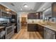 Modern kitchen featuring stainless steel appliances, granite countertops, and wood-style flooring at 3362 Partridge St, Deltona, FL 32738