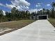 New construction home featuring a black roof and gutters, set on a verdant lawn at 3391 Orchid Dr, Indian Lake Estates, FL 33855