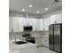 Bright kitchen with white cabinets, stainless steel appliances, and a subway tile backsplash at 3391 Orchid Dr, Indian Lake Estates, FL 33855