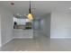 Open concept living area with tile floors, view of the modern kitchen and white cabinets at 3391 Orchid Dr, Indian Lake Estates, FL 33855