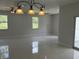 Spacious living area illuminated by natural light featuring contemporary tile flooring and modern light fixtures at 3391 Orchid Dr, Indian Lake Estates, FL 33855