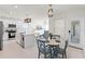 Modern kitchen with white cabinets, stainless steel appliances, an island with quartz countertops, and an adjacent dining area at 4063 Roaming Brook Dr, Apopka, FL 32712