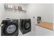 Modern laundry room with front-load washer and dryer and shelving for storage, creating an organized space at 4063 Roaming Brook Dr, Apopka, FL 32712