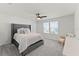 Cozy main bedroom with plush carpeting, large windows, ceiling fan and a comfortable upholstered bed at 4063 Roaming Brook Dr, Apopka, FL 32712
