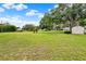 Expansive backyard featuring lush green grass, mature trees, and a storage shed perfect for outdoor activities at 409 Jumper S Dr, Bushnell, FL 33513