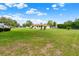 Expansive backyard with well-maintained lawn and view of the rear exterior of the home at 409 Jumper S Dr, Bushnell, FL 33513