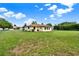 Spacious backyard featuring lush green lawn, a fenced area, and the home's rear exterior at 409 Jumper S Dr, Bushnell, FL 33513