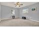 Bright bedroom featuring neutral walls, carpet, ceiling fan, and natural light from two windows at 409 Jumper S Dr, Bushnell, FL 33513
