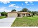 Charming single-story home featuring a two-car garage, stone accents, and a well-manicured lawn at 409 Jumper S Dr, Bushnell, FL 33513