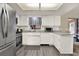 Updated kitchen with stainless steel appliances, white cabinets, and durable wood-look flooring at 409 Jumper S Dr, Bushnell, FL 33513