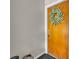 A close up of a stained wood front door decorated with a leafy green wreath and with gray walls at 4306 Lake Underhill Rd # C, Orlando, FL 32803